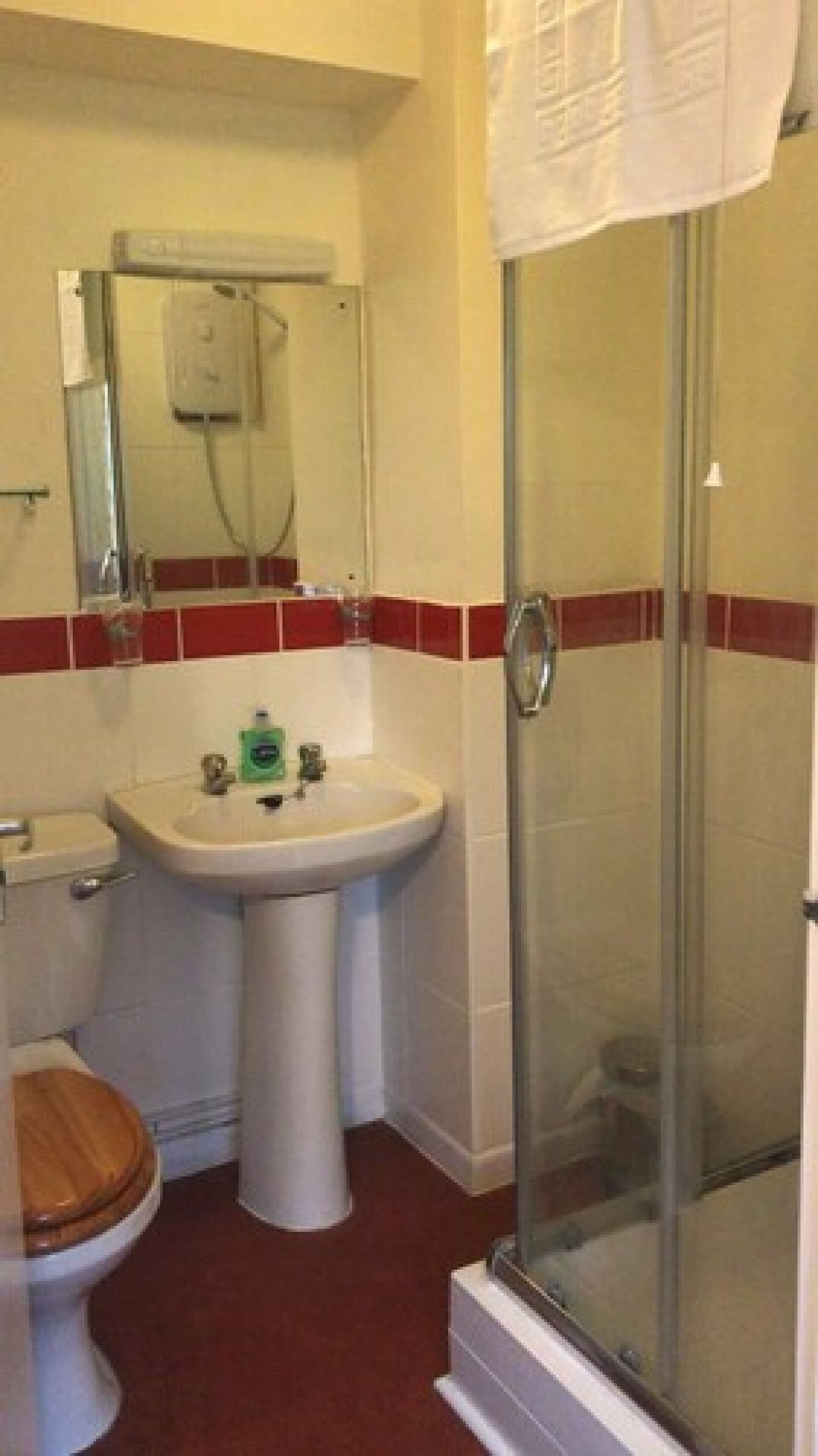 Un bagno con il water, lavandino e cabina doccia in vetro.