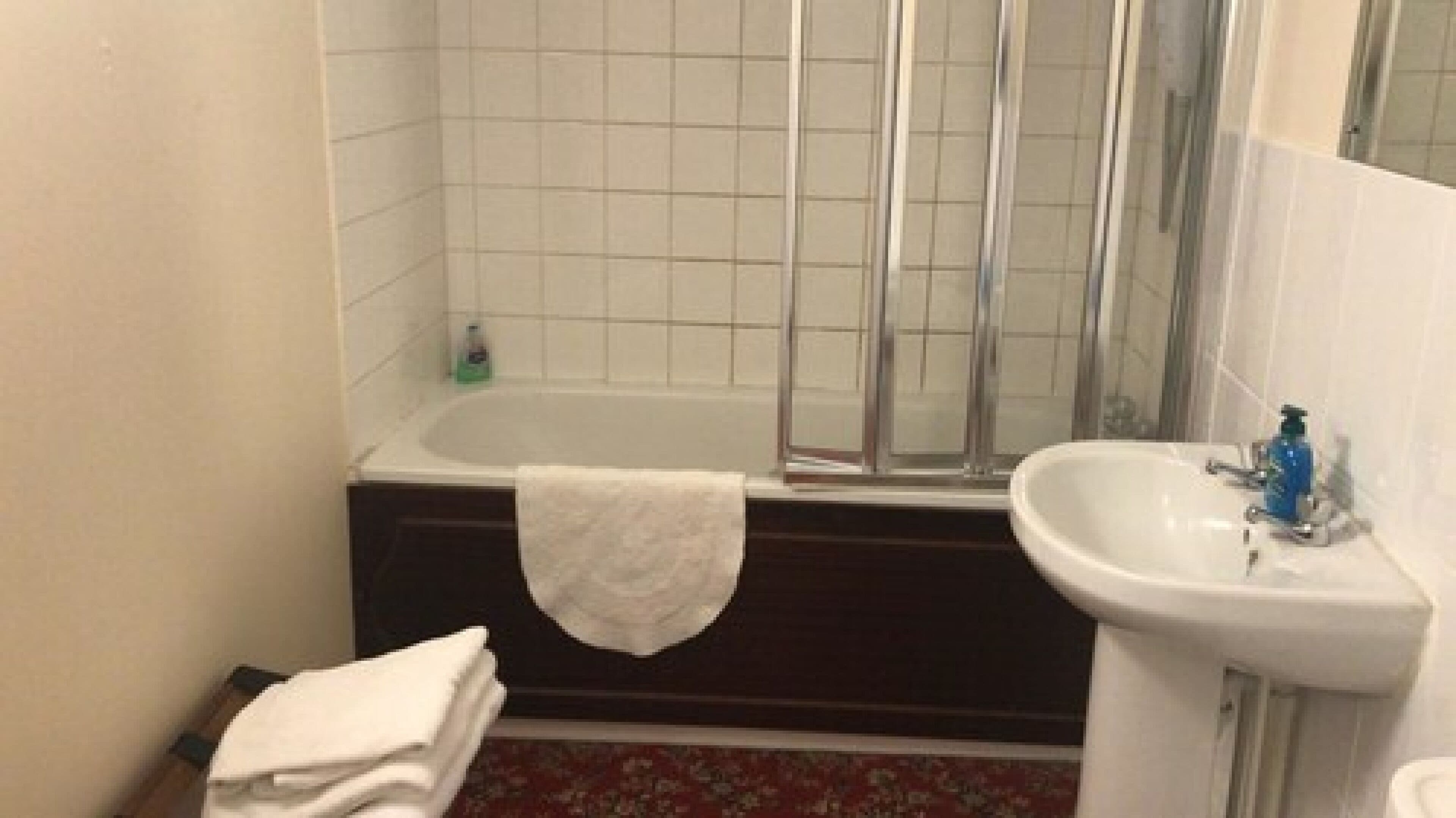 Un bagno con vasca, doccia e lavandino.