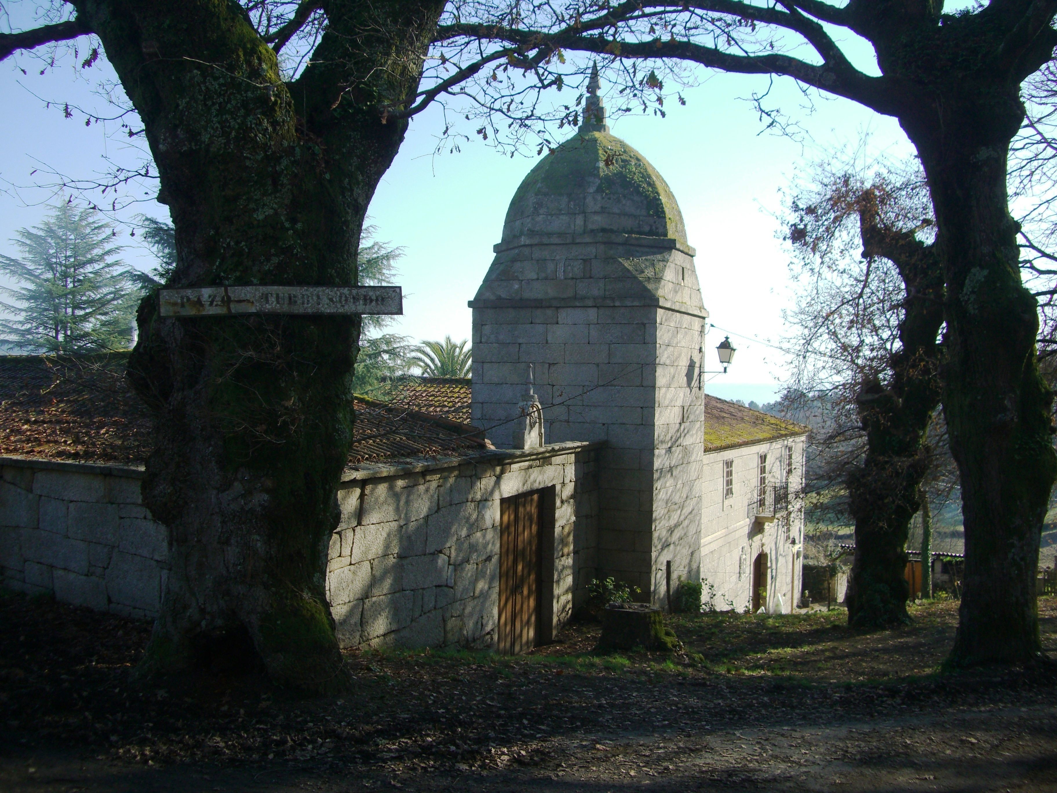Um edifício de pedra com cúpula, rodeado por árvores.