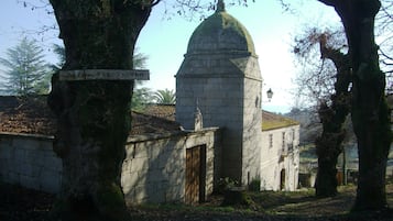 Um edifício de pedra com cúpula, rodeado por árvores.