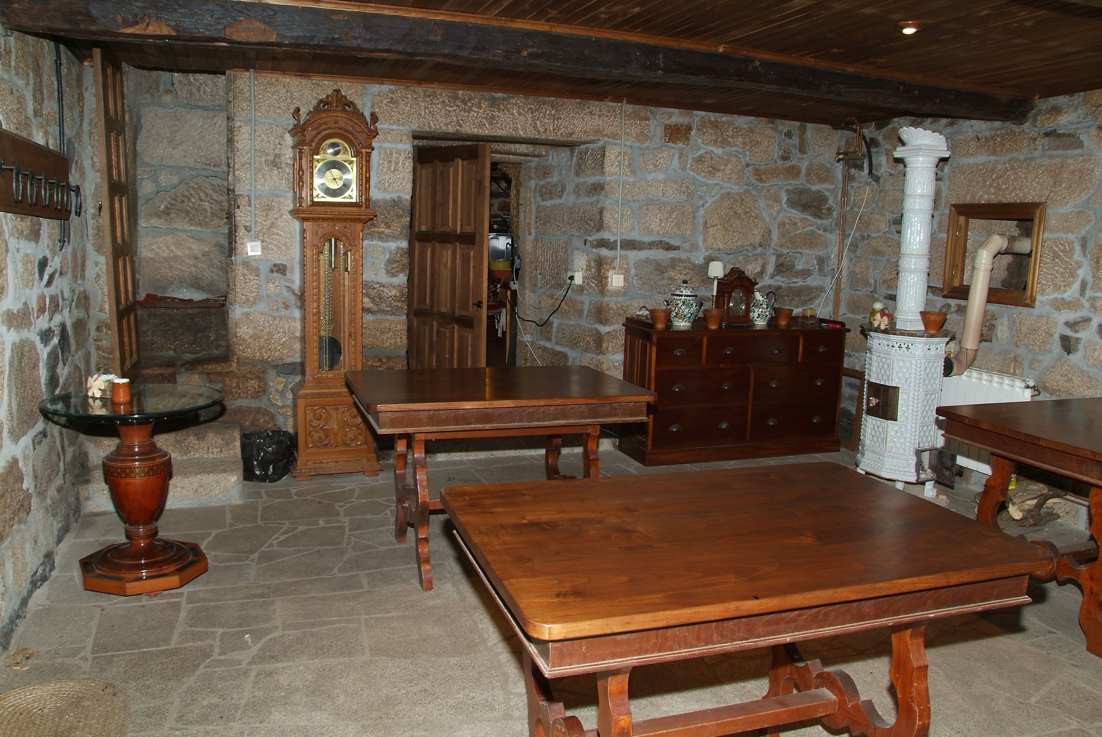 Une pièce rustique aux murs de pierre, meublée de meubles en bois et dotée d’une grande table en bois.