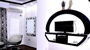 A modern room with a large window, a chair, and a wall-mounted TV. - Hotel Bouazza (Tiaret)