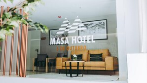 A modern hotel interior with a glass wall, a sofa, and a framed picture. - Masa Hotel 5 de Outubro (Lisbon)