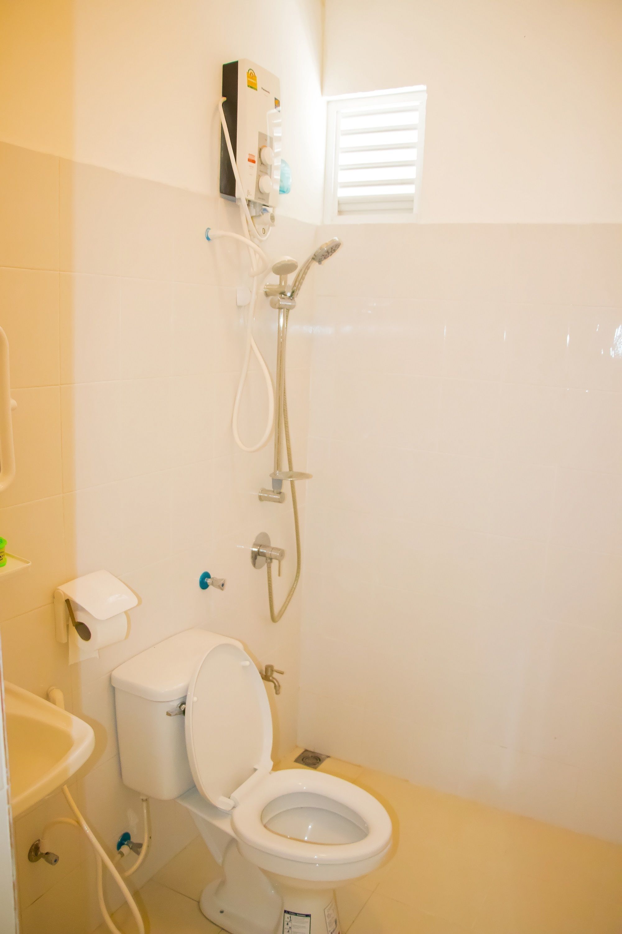 A bathroom with a toilet, sink, and shower.