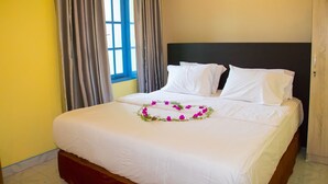 Una habitació d'hotel amb un llit, cortines i una finestra.