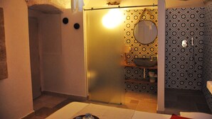 Een badkamer met een douche, een wastafel en een spiegel.