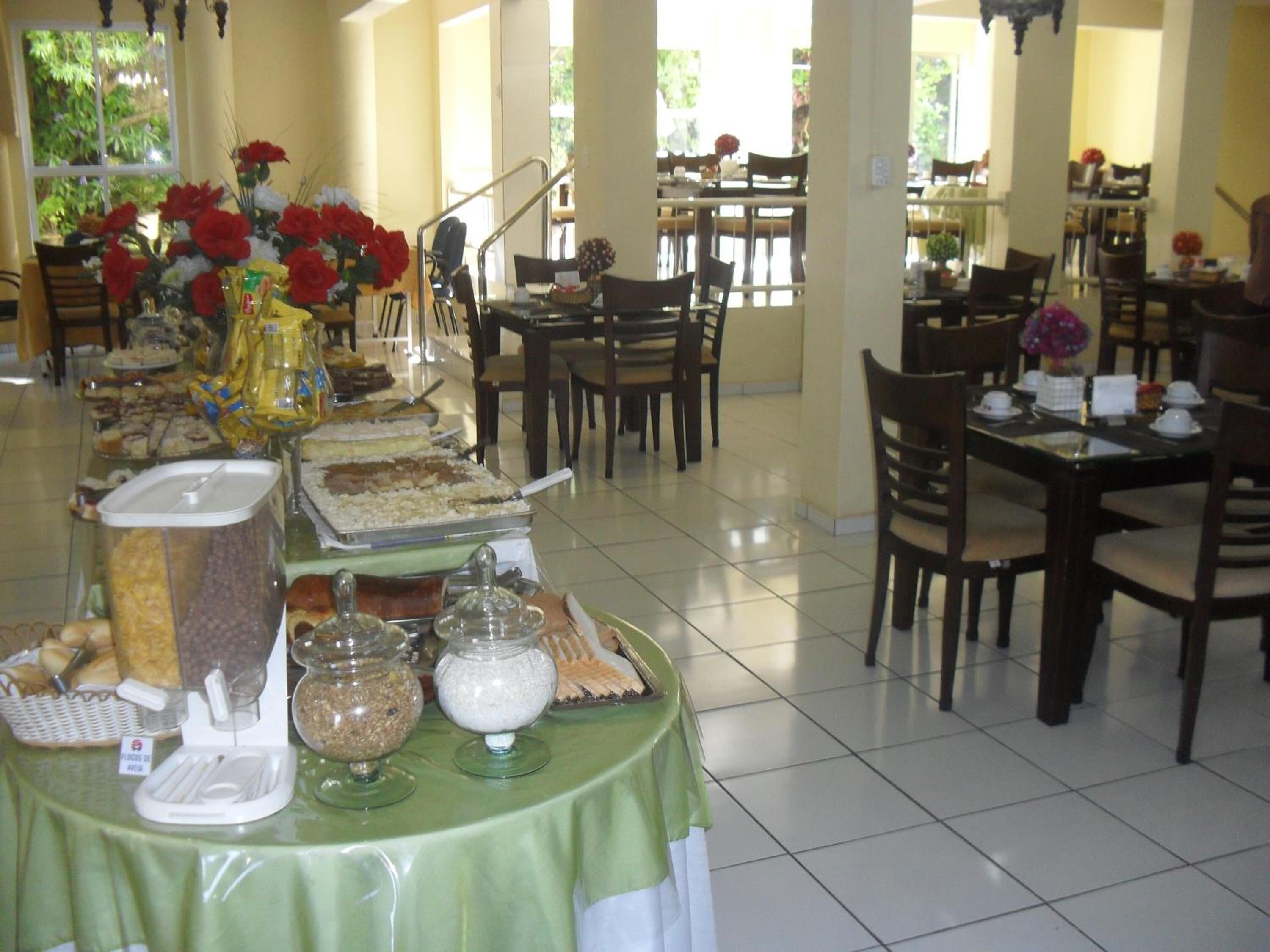 Montaje de bufé con diferentes alimentos y un mantel verde.