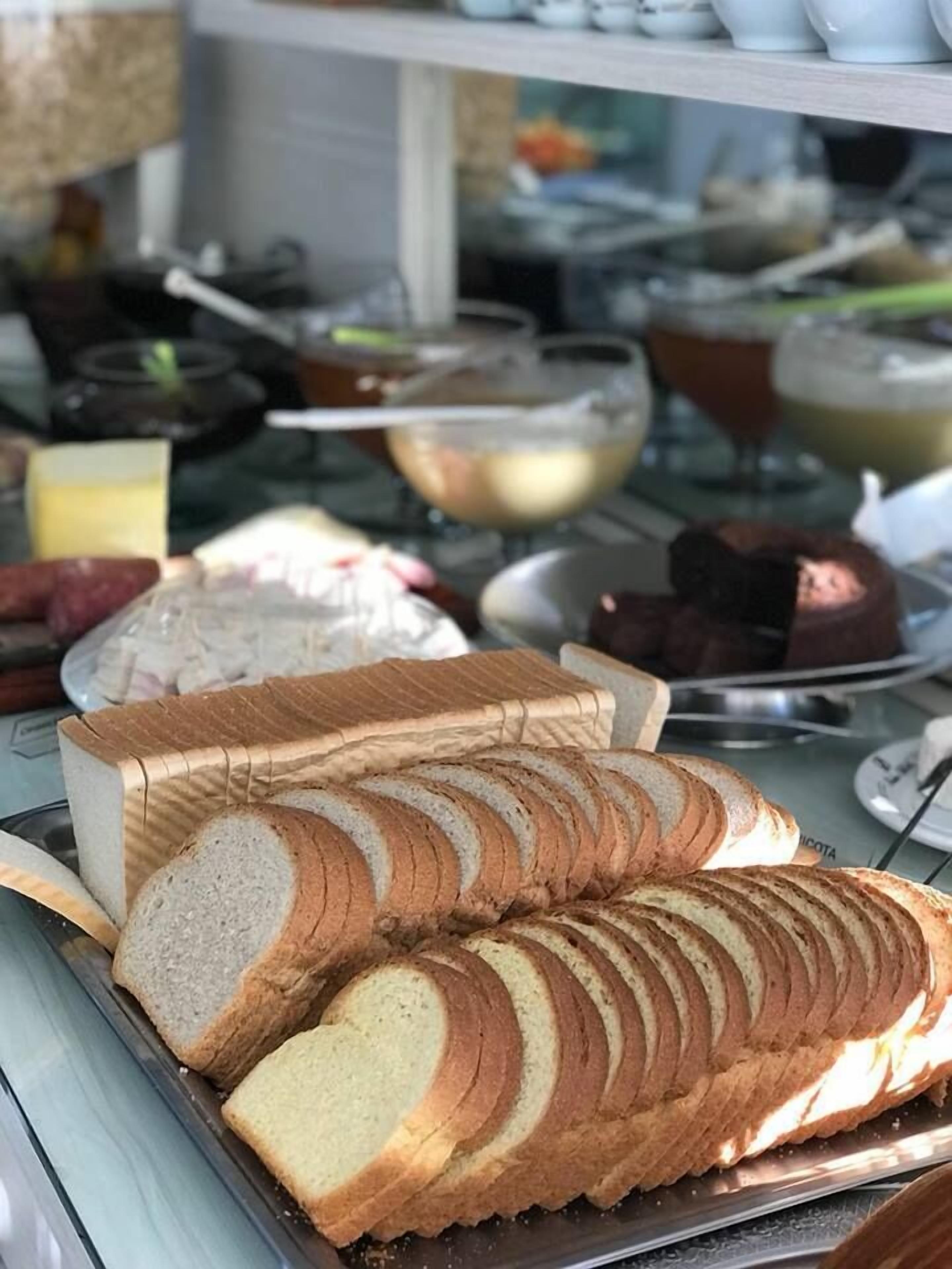 A buffet with various food items including bread, desserts, and beverages.