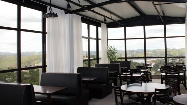 Un restaurante con amplios ventanales que ofrecen vistas al campo.