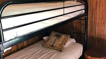 A bunk bed with two levels, each with a pillow featuring a palm tree design.