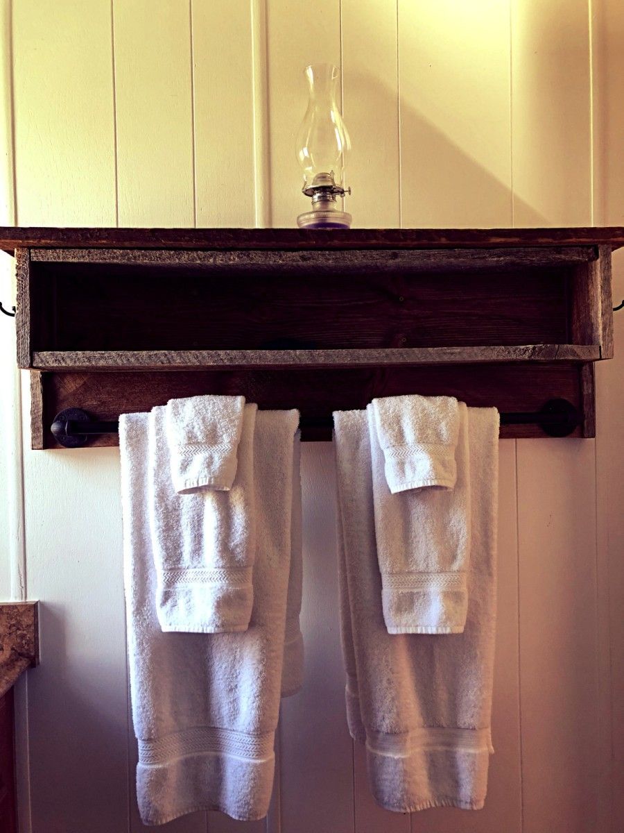 A wooden shelf with two towels hanging below it.