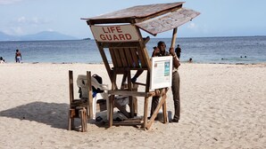A wooden lifeguard station on a beach with a sign that reads "LIFE GUARD". - Millsborough B&B (Kingston)