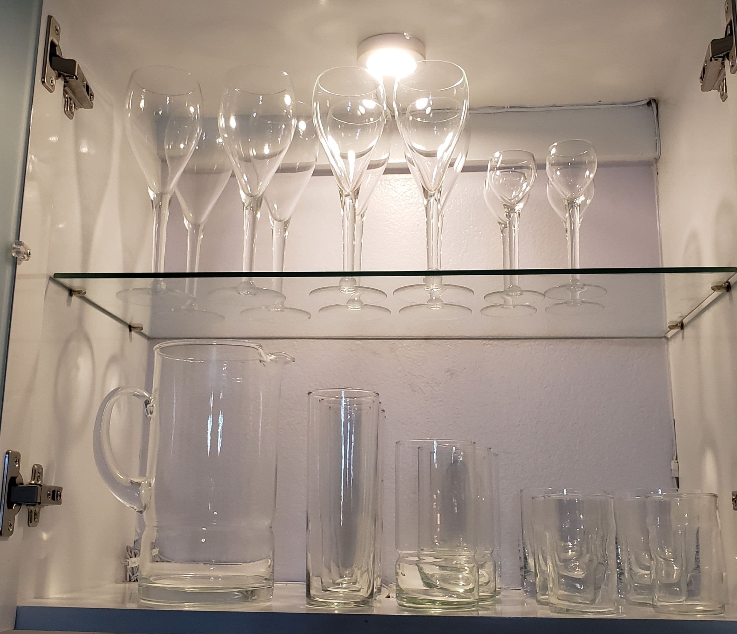 Una vetrina in vetro con bicchieri da vino e bicchieri tumbler.