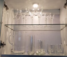 Una vetrina in vetro con bicchieri da vino e bicchieri tumbler.