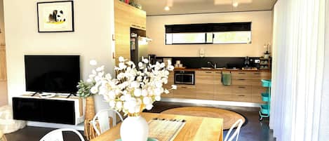 A modern kitchen with wooden cabinets, a built-in microwave, and a stainless steel sink.