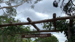 Un arco de madera con un letrero que dice "WELCOME TO HAPP'S".