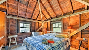 A wooden cabin bedroom with a bed, two windows, a ladder, and a desk. - Mattapoisett Home on 7 Acres w/ Private Beach! (Mattapoisett)
