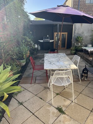 An outdoor patio with a table and chairs, a grill, and various potted plants. - South Melbourne terrace house.Short walk to Grand Prix,MSAC,Market,Pet friendly (South Melbourne)