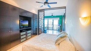 A bedroom with a bed, a TV, and a balcony. - Great 1 Bedroom Studio at Las Brisas by BRIC Vacation Rentals in Playa del Carmen (Playa del Carmen)