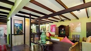 A spacious living area with a high ceiling, exposed beams, and a comfortable seating arrangement. - Celadon Holiday House @ PALM COVE (Palm Cove)