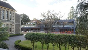 A courtyard with a stone building, a modern structure with a balcony, and a well-maintained lawn. - Shoreline 501 Sebel Kiama (Kiama)