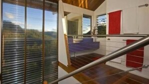 A modern kitchen with a view of the outdoors, a red towel hanging on the wall, and a wooden ceiling. - Off grid tranquillity with beautiful views and no other house in sight (Mapleton)