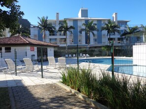 Relax by the pool surrounded by comfortable lounge chairs and umbrellas.