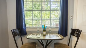 A small dining table with two chairs, a bottle of wine, and two glasses.