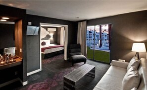 Relax in a stylish room with a comfortable bed, armchair, and flat-screen TV.