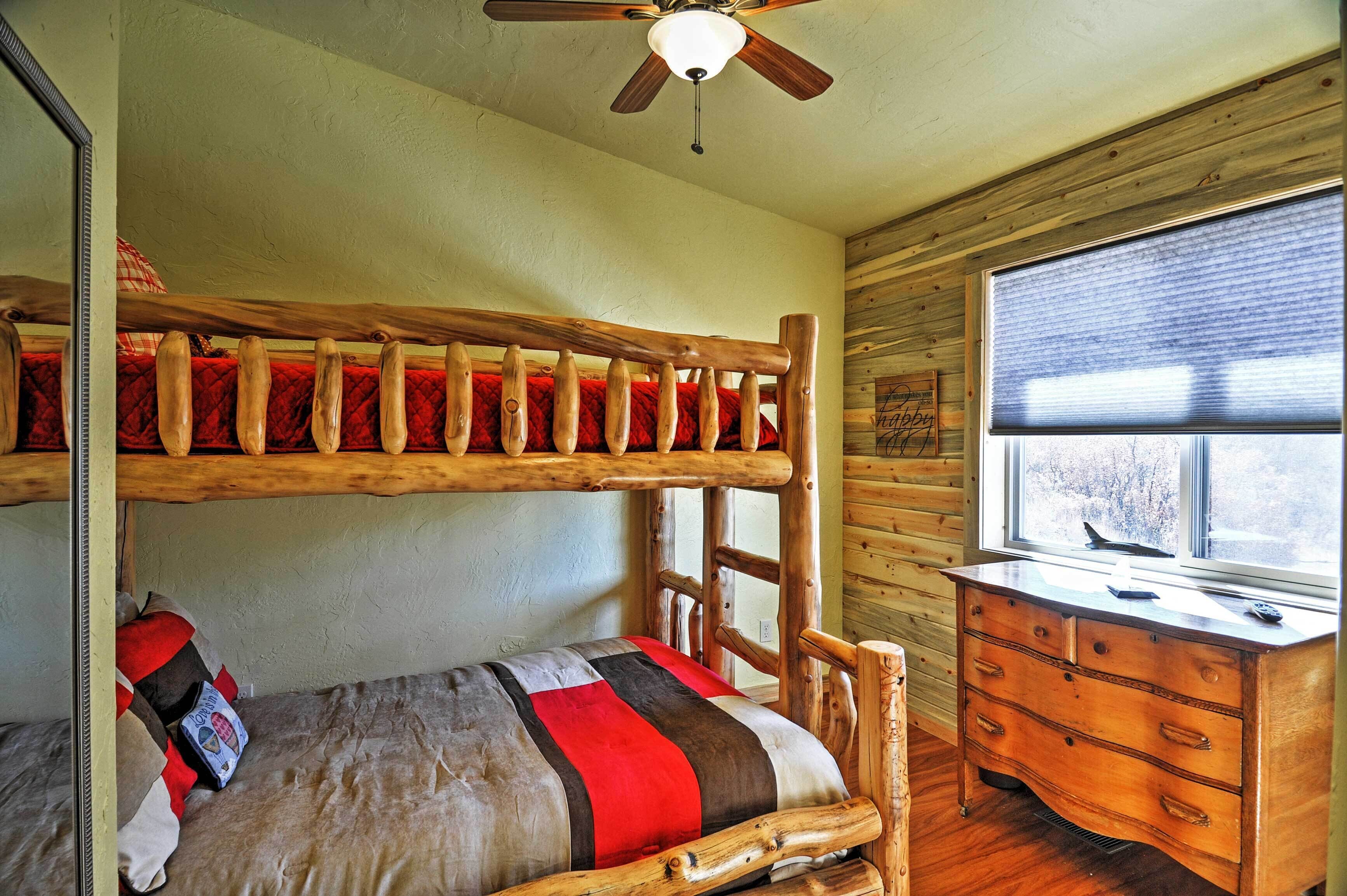 A bunk bed with a wooden frame and a dresser with drawers.