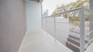 A modern staircase with a metal railing, leading to an outdoor area with a view of trees and a building in the background. - WX4 Venezuela Apartment (Córdoba)