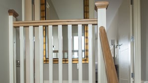 Een trap met houten leuningen en witte spijbels.