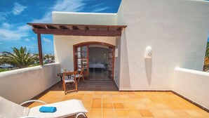 Un balcone con una sedia, un tavolo e un asciugamano blu.