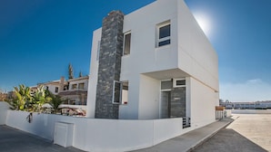 Un bâtiment moderne à deux étages, doté d’une façade blanche et d’un mur d’accent en pierre.
