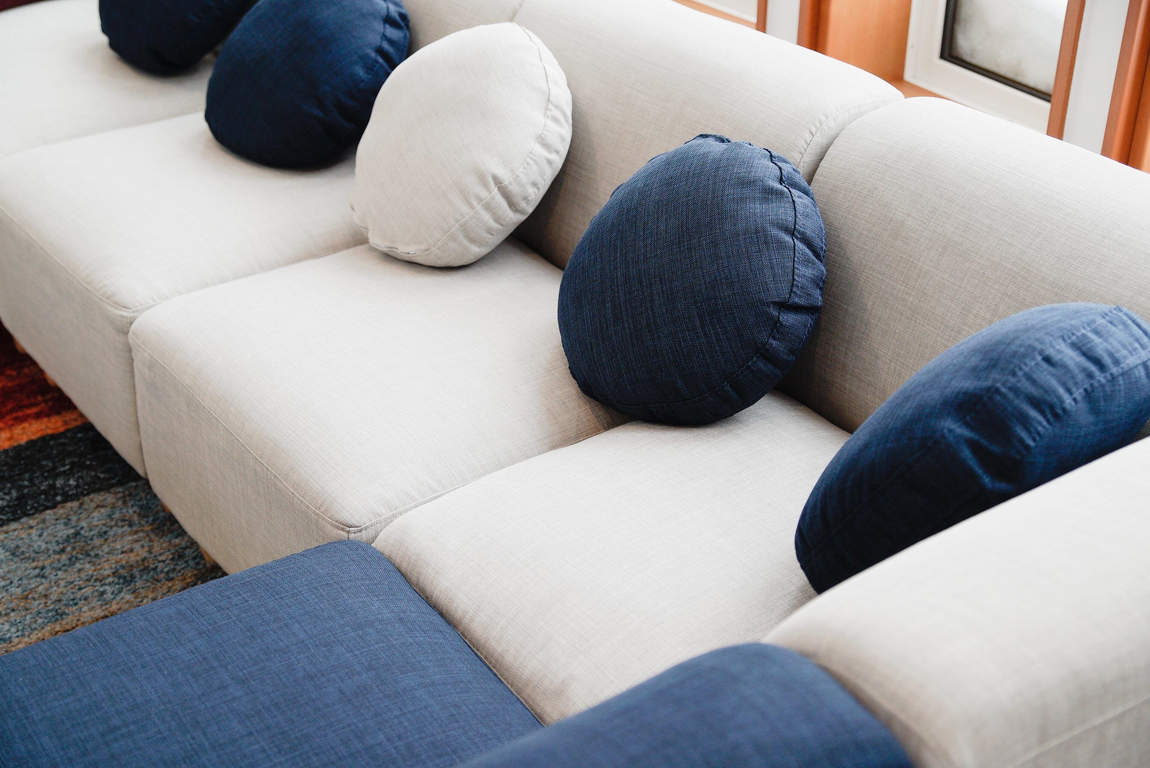 Un sofá modular con muchos cojines en tonos azul y blanco.