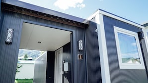 A modern building with a large entrance, a visible door, and a small window. - Jstyle STAY Furano (Furano)