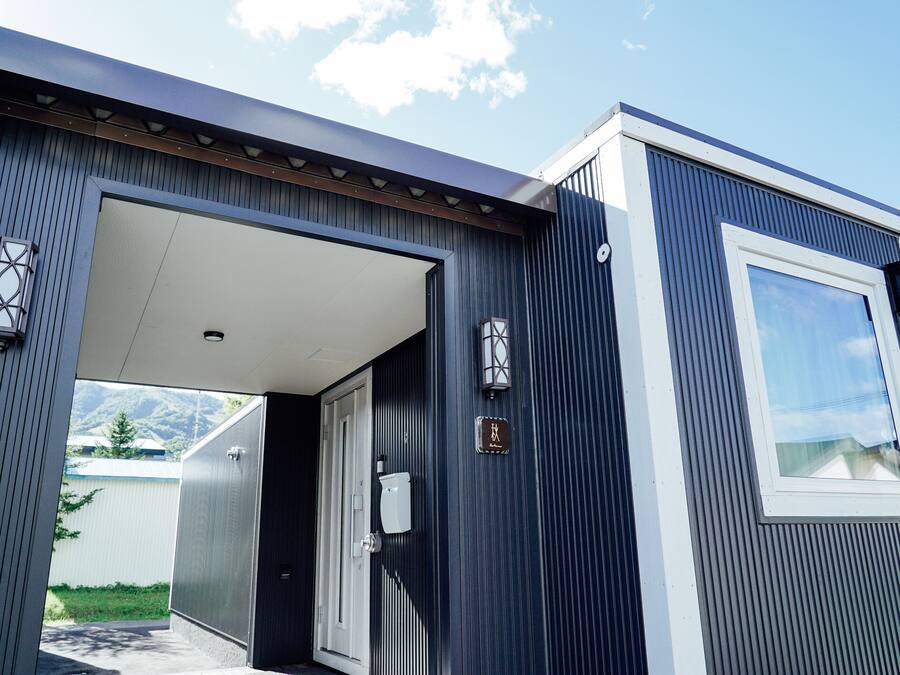 A modern building with a large entrance, a visible door, and a small window.