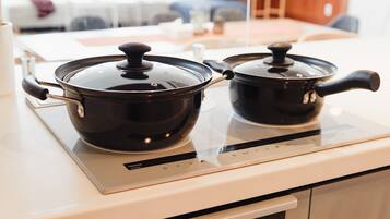 Two black pots on a modern induction cooktop.