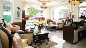A spacious lobby with leather sofas, a marble coffee table, and a reception desk. - Sugar Land Villa Hotel Dalat (Xuan Huong - Da Lat)