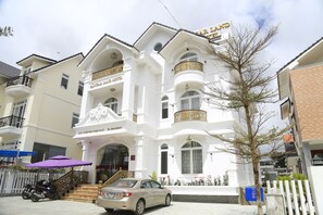 Un edifici blanc amb balcons i un rètol que diu "SUGAR PINE HOTEL".