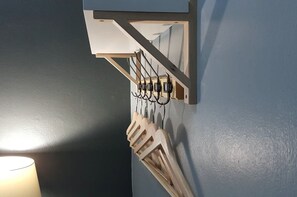 A wall-mounted coat rack with hooks and a wooden coat stand. - Baan Pinklao (Bangkok)
