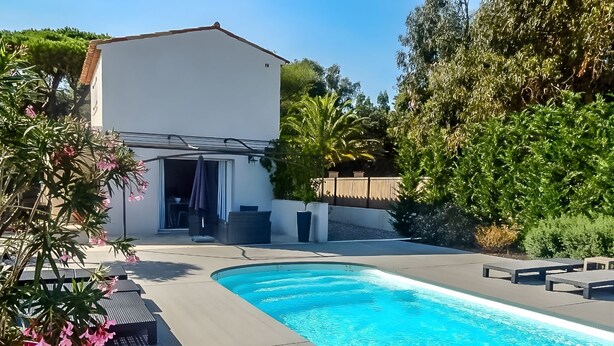A swimming pool with a patio area, a covered outdoor seating area, and a building with a white facade. - Esprit du Sud Esterel (Sainte-Maxime)