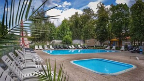 A pool area with multiple lounge chairs and a clear blue pool.