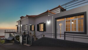 Ein modernes Haus mit Balkon, Treppe und Meerblick.