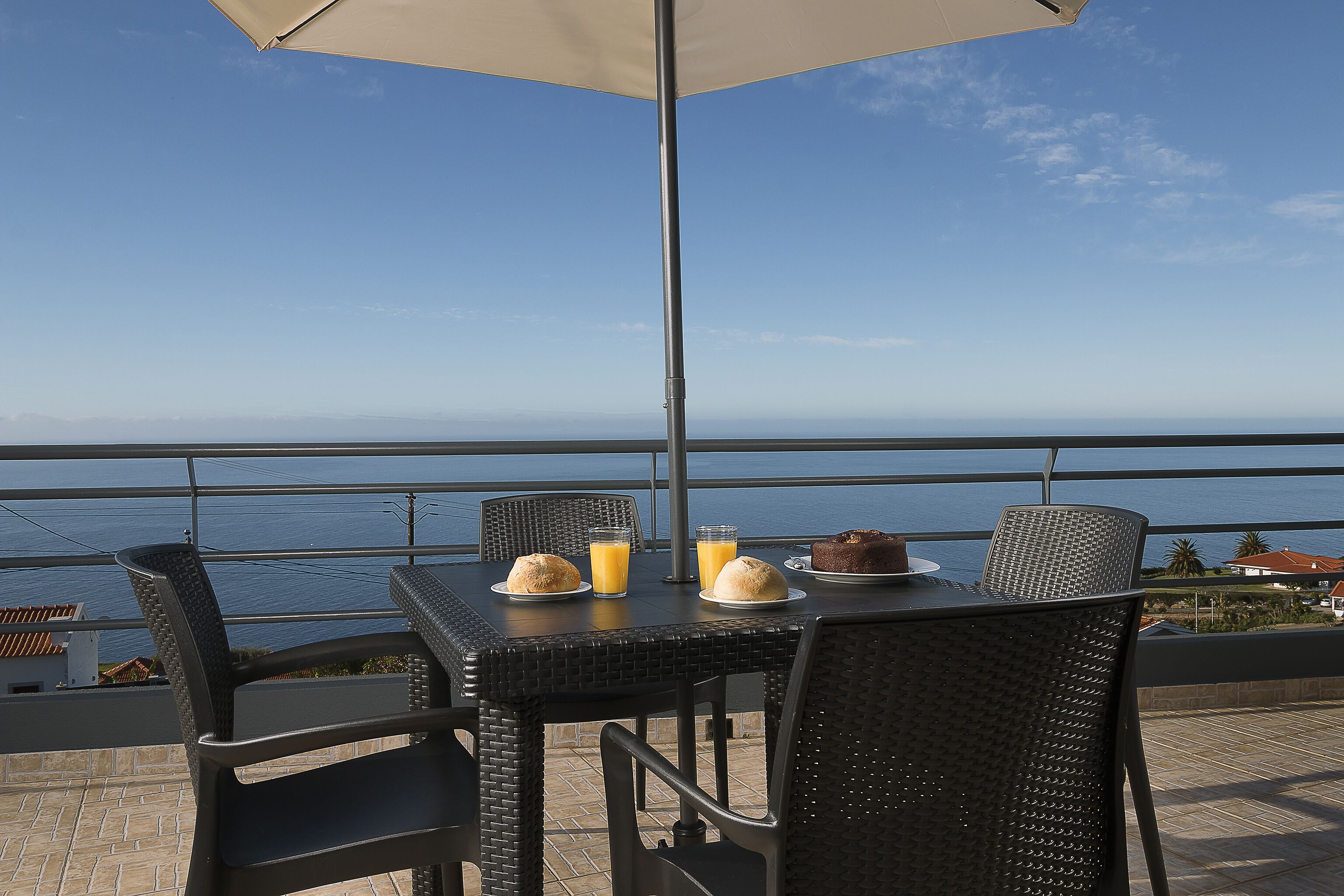 A table with breakfast items and a view of the sea.