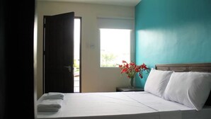 A hotel room with a bed, a window, and a door. - Rana Hotel (Cebu City)