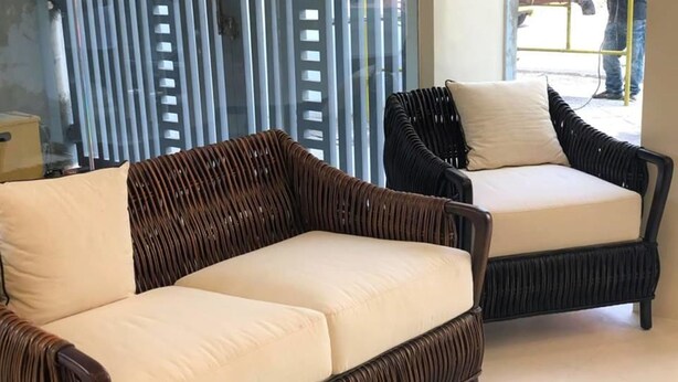 Two wicker sofas with cream cushions in a room with a glass door and blinds. - Rana Hotel (Cebu City)