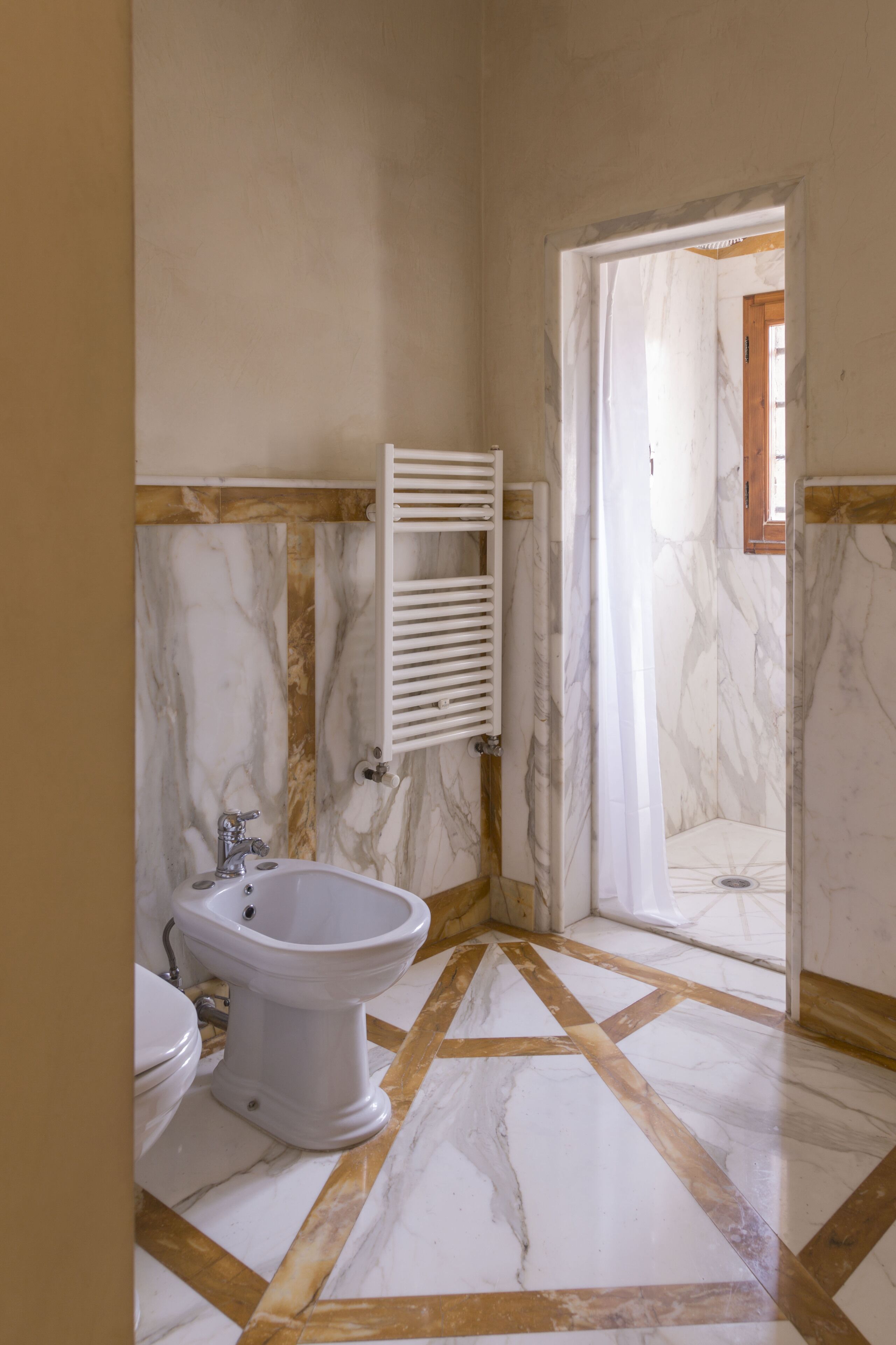 Un baño con inodoro, bidé y zona de ducha.