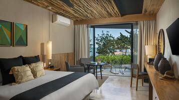 Habitación de hotel con una cama grande, un escritorio, una silla, una mesa y vistas al exterior.
