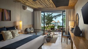 Une chambre d’hôtel moderne avec un grand lit, un bureau et une vue sur la plage.